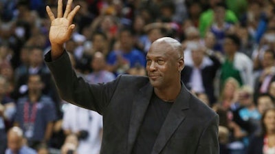 In this Oct. 11, 2015 file photo, NBA basketball legend Michael Jordan waves during the match of Charlotte Hornets against the Los Angeles Clippers at the 2015 NBA Global Games in Shenzhen, south China's Guangdong province. China's highest court ruled Thursday, Dec. 8, 2016, in favor of Jordan at the conclusion of a years-long trademark case. The former NBA star has been in dispute with a sportswear company based in southern China called Qiaodan Sports since 2012.