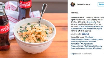 This image provided by Vox Media shows a social media post featuring a bottle of Coca-Cola next to a bowl of chicken chili. Coca-Cola is trying to sell more of its flagship beverage by suggesting the cola can accompany a wide range of meals, rather than just the fast food and pizza with which it’s a mainstay.