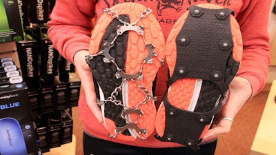 Emma Bohman, a sales associate at Skinny Raven sporting goods, shows two kinds of exterior cleats attached to running shoes in Anchorage, Alaska. Exterior cleats are one of many ways Anchorage residents cope with up ice on streets up to seven months per year.