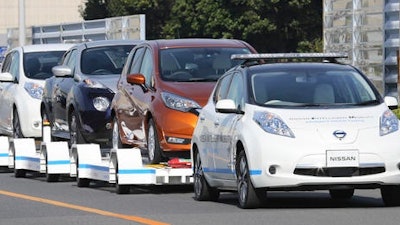 Nissan Motor Co.'S 'Leaf', with no one inside, pulls a trailer with three other Leafs on it, during a demonstration of the automaker's Intelligent Vehicle Towing system at Nissan Oppama plant in Yokohama, near Tokyo Monday, Dec. 5, 2016. Nissan Motor Co. is testing out self-driving cars at one of its plants in Japan to tow vehicles on a trailer to the wharf for loading without anyone behind the steering wheel.