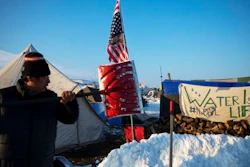 Benji Buffalo, a Grovan Native American from Montana, shovels snow outside his tent at the Oceti Sakowin camp where people have gathered to protest the Dakota Access oil pipeline in Cannon Ball, N.D., Saturday, Dec. 3, 2016.
