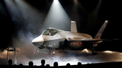 In this July 7, 2006, file photo, the Lockheed Martin F-35 Joint Strike Fighter is shown after it was unveiled in a ceremony in Fort Worth, Texas. Shares of Lockheed Martin fell Monday, Dec. 12, 2016, as President-elect Donald Trump tweeted that making F-35 fighter planes is too costly and that he will cut 'billions' in costs for military purchases.