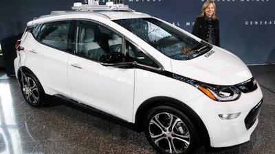 General Motors Chairman and Chief Executive Officer Mary Barra stands next to an autonomous Chevrolet Bolt electric car Thursday, Dec. 15, 2016, in Detroit. General Motors has started testing fully autonomous vehicles on public roads around its technical center in suburban Detroit.