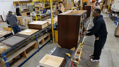 Joe Battles installs drawers in a cabinet at Bertch Cabinet in Waterloo, Iowa, Thursday, Dec. 15, 2016.