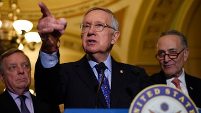 Senate Minority Leader Harry Reid of Nev., flanked by Senate Minority Whip Richard Durbin of Ill., left, and Senate Minority Leader-elect Charles Schumer of N.Y., answers questions from the media after the Democratic policy luncheon on Capitol Hill in Washington, Tuesday, Dec. 6, 2016.