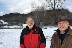 In this Dec. 8, 2016 photo, Steve Burke and Jim Besha of Albany Engineering Corp. stand at the site of an abandoned iron mine in the Adirondacks, in Mineville, N.Y., where they're seeking a federal permit to build an underground hydroelectric pumped storage project. The hills behind them are 'tailings' leftover from crushing ore to extract iron from the mine that closed in 1971.