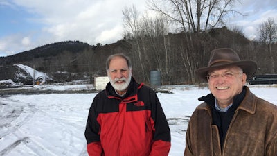 In this Dec. 8, 2016 photo, Steve Burke and Jim Besha of Albany Engineering Corp. stand at the site of an abandoned iron mine in the Adirondacks, in Mineville, N.Y., where they're seeking a federal permit to build an underground hydroelectric pumped storage project. The hills behind them are 'tailings' leftover from crushing ore to extract iron from the mine that closed in 1971.