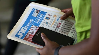 In this Tuesday, July 19, 2016, file photo, a job applicant attends a job fair in Miami Lakes, Fla. On Wednesday, Dec. 7, 2016, the Labor Department reports on job openings and labor turnover for October.