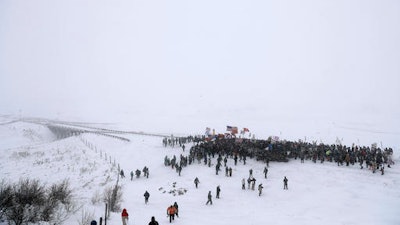 Military veterans march to a closed bridge outside the Oceti Sakowin camp where people have gathered to protest the Dakota Access oil pipeline in Cannon Ball, N.D., Monday, Dec. 5, 2016.