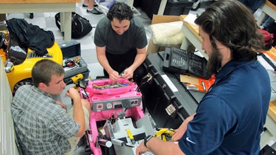 In this Thursday, Dec. 1, 2016, photo, University of North Florida students, Garrett Baumann, right, Chris Martin, center, and Jason Pavichall, work to customize a toy car so that it can be used by a girl with cerebral palsy at the university in Jacksonville, Fla. At the university, engineering and physical therapy students are converting drivable toy cars from store shelves into custom-made fun for disabled children. The Adaptive Toy program is now in its third year, has received a 5-year grant from the National Institutes of Health and is helping families with disabled children while giving the students a dose of community service that will stick with them long after graduation.