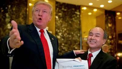 President-elect Donald Trump, accompanied by SoftBank CEO Masayoshi Son, speaks to members of the media at Trump Tower in New York, Tuesday, Dec. 6, 2016.