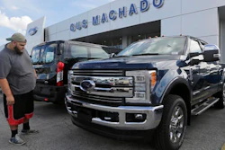 In this Tuesday, Jan. 17, 2017, photo, a potential customer looks at a 2017 Ford F-250 Lariat FX4 at a Ford dealership, in Hialeah, Fla. Ford Motor Company reports financial results Thursday, Jan. 26, 2017.