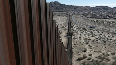 In this Jan. 25, 2017 photo, a truck drives near the Mexico-US border fence, on the Mexican side, separating the towns of Anapra, Mexico and Sunland Park, New Mexico.