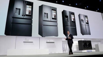 John Herrington, senior vice president of Samsung Electronics America, unveils new refrigerators with Family Hub 2.0 during a Samsung news conference before CES International, Wednesday, Jan. 4, 2017, in Las Vegas. Family Hub 2.0 features an interface on the refrigerator with apps that can be controlled by voice recognition.