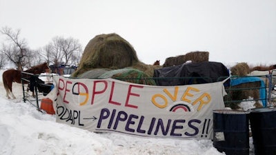 Hay is stacked up to feed horses at a protest encampment along the route of the Dakota Access oil pipeline near Cannon Ball in southern North Dakota on Tuesday, Jan. 24, 2017. President Donald Trump on Tuesday issued an executive action to advance construction of the pipeline, which opponents believe threatens drinking water and cultural sites. The pipeline developer disputes that.