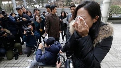 A family member of a victim of toxic humidifier disinfectants weeps during a press conference against court's sentence at the Seoul Central District Court in Seoul, South Korea, Friday, Jan. 6, 2017. A South Korean court has sentenced the former head of Oxy Reckitt Benckiser to seven years in prison after the company's disinfectant for humidifiers killed scores of people.