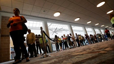 In this Sept. 3, 2014 file photo, people wait in line to sign up for unemployment in Atlantic City, N.J. The proportion of men in their prime working years who have a job has been steadily declining _ and holding back the United States’ growth potential. The full brunt of this 60-year decline became apparent during the 2016 election. Trump won the electoral college in large part by calling for more jobs at steel mills, auto plants and coal mines, the types of work that had once employed legions of men who lacked a college education.