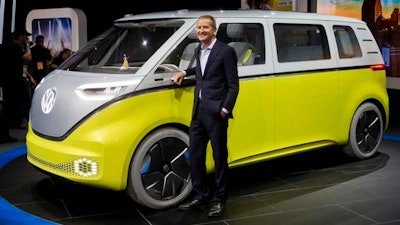 In a Jan. 9, 2017, file photo, Herbert Diess, chairman of the Volkswagen brand, poses with the I.D. Buzz all-electric concept van, at the North American International Auto Show, in Detroit. The I.D. Buzz seats up to eight and lets the driver’s seat face the rear when the minivan is in self-driving mode. VW minibuses haven’t been sold in the U.S. since the 1970s, but the company has released several concepts over the years that take their styling cues from the beloved minibus.