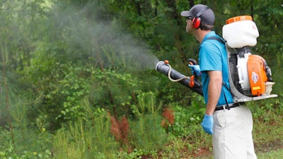 In this Friday, May 16, 2014, file photo, Daniel Lewis, Mosquito Authority, sprays to kill mosquitos before the summer season.
