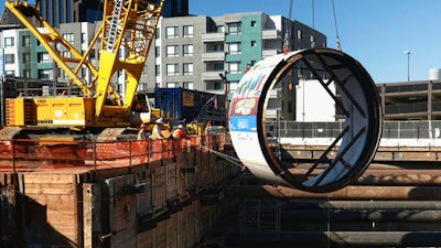 In this Oct. 19, 2016, file photo, workers lower the tail shield section of a tunnel boring machine into a 45 foot deep pit, during a ceremonial naming and lowering for the Regional Connector Transit Project downtown Los Angeles. Just weeks after suddenly tweeting 'Traffic is driving me nuts' and 'am going to build a tunnel boring machine and just start digging,' Elon Musk, the SpaceX and Tesla founder says it's on the verge of happening. 'Exciting progress on the tunnel front,' he tweeted Wednesday, Jan. 25, 2017. 'Plan to start digging in a month or so.'