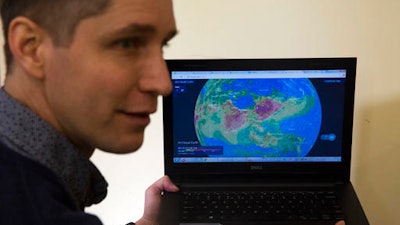 In this Jan. 13, 2017 photo, Yann Boquillod, founder of start-up AirVisual, talks about a 3-D real-time global map of air pollution at the Ivy Bilingual School in Beijing. There is no quick fix to the Chinese capital’s dirty skies, so Beijing residents are finding ways to cope with and adapt to the air pollution. Bodin said he thinks every house should have an air filtering and ventilation system pre-installed. Boquillod wanted to know what kind of air his five children were breathing at home, so he developed a portable air quality monitor.