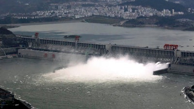 In this Nov. 7, 2008 photo, flow of water is discharged through the Three Gorges Dam in Yichang in central China's Hubei province. State-owned China Three Gorges Group is spending heavily to buy or build hydro, wind and solar projects at a time when Western utility investors are pulling back and U.S. President-elect Donald Trump’s pledge to revive coal use has raised doubt about U.S. support for renewables.