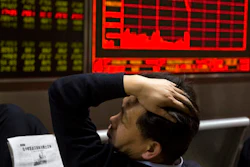 In this Wednesday, Nov. 9, 2016, file photo, a Chinese man reacts near a board showing the Shanghai Stock Exchange Composite Index at a brokerage in Beijing, China. A board member of the American Chamber of Commerce in China, Lester Ross, says China is preparing to retaliate if U.S. President-elect Donald Trump carries out promises to impose sanctions on Chinese goods.
