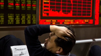 In this Wednesday, Nov. 9, 2016, file photo, a Chinese man reacts near a board showing the Shanghai Stock Exchange Composite Index at a brokerage in Beijing, China. A board member of the American Chamber of Commerce in China, Lester Ross, says China is preparing to retaliate if U.S. President-elect Donald Trump carries out promises to impose sanctions on Chinese goods.