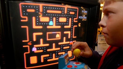 In this Oct. 5, 2004, file photo, Jake Gautney, 12, of Chappaqua, N.Y., tries a Ms. Pac-Man game at the Toy Industry Association holiday preview in New York. Masaya Nakamura, the 'Father of Pac-Man' who founded the Japanese video game company behind the hit creature-gobbling game, died on Jan. 22, 2017. He was 91.
