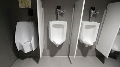 A waterless urinal, left, is shown next to standard urinals at the University of Michigan engineering building, Tuesday, Jan. 24, 2017, in Ann Arbor, Mich. The waterless toilet is connected to a collection and filtration system which is part of a multi-state project researching the conversion of human urine into fertilizer.