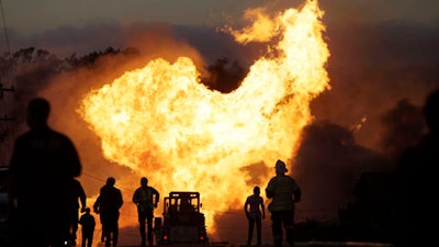 In this Sept. 9, 2010 file photo, a massive fire roars through a neighborhood in San Bruno, Calif. Pacific Gas & Electric Co. says it is prepared to pay the maximum fine of $3 million after a jury convicted the company of deliberately violating pipeline safety regulations before a deadly natural gas pipeline explosion in the San Francisco Bay Area and then misleading investigators looking into the blast.