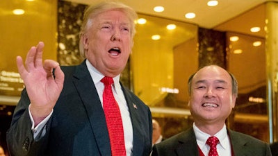 In this Tuesday, Dec. 6, 2016, file photo, President-elect Donald Trump, left, accompanied by SoftBank CEO Masayoshi Son, speaks to members of the media at Trump Tower in New York. Trump gave himself kudos for the creation of 8,000 new U.S. jobs by Japanese tech mogul Son, saying it was proof of 'the spirit and the hope' stirred by his presidential win. But for those particular jobs, Trump was basically taking a bow for the second time.
