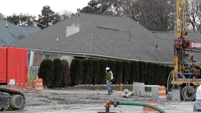 A construction worker walks by a home collapsed by a sinkhole in Fraser, Mich. Water conservation efforts helped prevent bigger problems related a suburban Detroit sinkhole during the Super Bowl.
