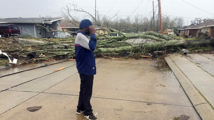 Silas Battie walks around the east New Orleans neighborhood after a tornado touchdown, Tuesday, Feb. 7, 2017. At least three tornadoes touched down, causing damage to buildings.