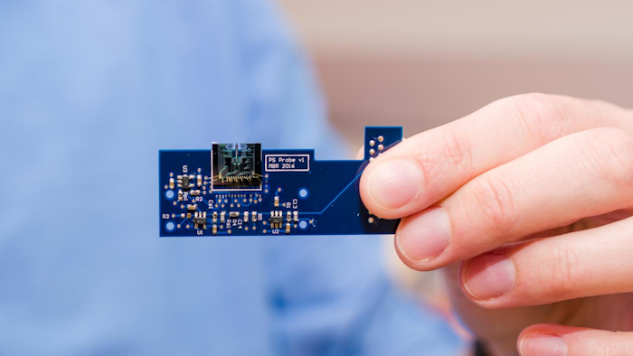 A MEMS-based atomic force microscope developed by engineers at the University of Texas at Dallas is about 1 square centimeter in size (top center). Here it is attached to a small printed circuit board that contains circuitry, sensors and other miniaturized components that control the movement and other aspects of the device.