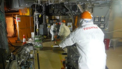 In this photo released by Tokyo Electric Power Co. (TEPCO), workers prepare to operate a remote-controlled 'cleaning' robot at Unit 2 of Fukushima Dai-ichi nuclear power plant in Okuma town, Fukushima prefecture, northeastern Japan, Thursday, Feb. 9, 2017. The 'cleaning' robot that entered one of three tsunami-wrecked Fukushima reactor containment chambers was withdrawn before completing its mission due to glitches most likely caused by high radiation.
