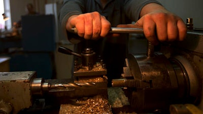 On this Thursday, Feb. 9, 2017 photo lathe operator Roman Ilyukhin fixes a brass bar in a machine-tool's spindle to make a microphone's part at a factory in Tula, Russia. In Tula, a city packed with the Russian defence industry, Californian musician David Brown and fan Pavel Bazdyrev have been making high-end microphones since 2014, taking advantage of cheap labor and second hand machinery from Kalashnikov arms plants. Ilyukhin, says his wage of 60,000 rubles ($1,000) is almost double what he used to earn elsewhere in the city.