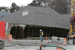 A construction worker walks by a home collapsed by a sinkhole in Fraser, Mich. Water conservation efforts helped prevent bigger problems related a suburban Detroit sinkhole during the Super Bowl.