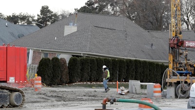 A construction worker walks by a home collapsed by a sinkhole in Fraser, Mich. Water conservation efforts helped prevent bigger problems related a suburban Detroit sinkhole during the Super Bowl.