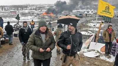 Tori Ramos, left, and Riley Cogburn, both of Albany, N.Y., leave as opponents of the Dakota Access pipeline leave their main protest camp Wednesday, Feb. 22, 2017, near Cannon Ball, N.D. Most of the pipeline opponents abandoned their protest camp Wednesday ahead of a government deadline to get off the federal land, and authorities moved to arrest some who defied the order in a final show of dissent.