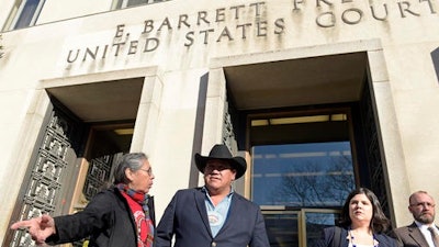 Cheyenne River Sioux Chairman Harold Frazier, center, talks with Madonna Thunder Hawk, left, of the Oohenumpa band of the Cheyenne River Sioux Tribe, before speaking to reporters outside federal court in Washington, Monday, Feb. 13, 2017. A judge has rejected a request by two American Indian tribes to halt construction of the remaining section of the Dakota Access oil pipeline until their lawsuit over the project is resolved.