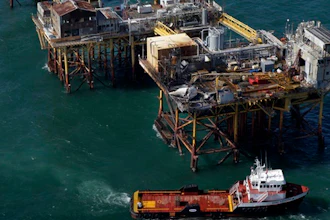 In this Friday, Nov. 16, 2012, file aerial photo, a supply vessel moves near Black Elk Energy's oil platform damaged by an explosion and fire in the Gulf of Mexico about 17 miles from Grand Isle, La. An oil industry services company will pay $9.5 million in penalties for Gulf of Mexico safety violations and for pollution from the 2012 offshore platform fire that killed three workers. The penalties against Houston-based Wood Group PSN were announced Thursday, Feb. 23, 2017, by the U.S. Justice Department in Washington and U.S. attorneys in New Orleans and Lafayette, Louisiana, where civil and criminal cases have been playing out.