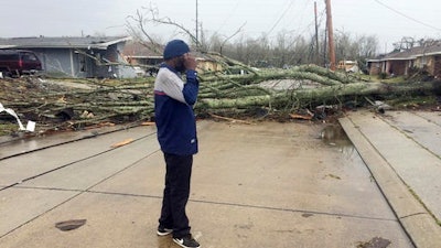 Silas Battie walks around the east New Orleans neighborhood after a tornado touchdown, Tuesday, Feb. 7, 2017. At least three tornadoes touched down, causing damage to buildings.