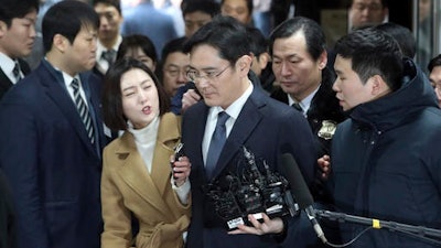 Lee Jae-yong, the vice chairman of Samsung Electronics, center, is questioned by reporters upon his arrival for a hearing at the Seoul Central District Court in Seoul, South Korea, Thursday, Feb. 16, 2017. A South Korean court has begun deliberating on whether to issue an arrest warrant for the Samsung heir accused of offering bribes to the country's president and her close friend. Lee walked into the court on Thursday without speaking.