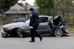In this Nov. 1, 2016 file photo, a member of the Baltimore Police Department walks past a car that was damaged by a school bus before the bus was involved in a fatal collision with a commuter bus in Baltimore. A jump in traffic fatalities last year pushed deaths on U.S. roads to their highest level in nearly a decade, erasing improvements made during the Great Recession and economic recovery, a leading safety organization said Wednesday, Feb. 15, 2015.