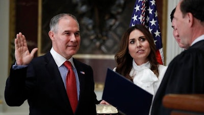 Supreme Court associate justice Samuel Alito, right, swears in Scott Pruitt as the Environmental Protection Agency Administrator in the Eisenhower Executive Office Building in the White House complex in Washington, Friday, Feb. 17, 2017. Holding the bible is Marlyn Pruitt, wife of Scott Pruitt, and their son Cade Pruitt is standing second from right.