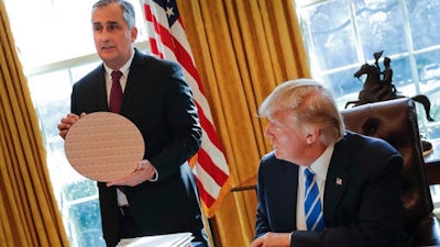 President Donald Trump looks at Intel CEO Brian Krzanich, holding a silicon wafer, during their meeting in the Oval Office of the White House in Washington, Wednesday, Feb. 8, 2017.