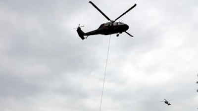 A helicopter carries sandbags in the direction of a damaged dam Wednesday, Feb. 15, 2017, in Oroville, Calif. The Oroville Reservoir is continuing to drain Wednesday as state water officials scrambled to reduce the lake's level ahead of impending storms.