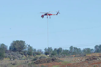 A Skycrane helicopter lowers a load of rocks to fill in a hole on the Oroville Dam's emergency spillway, Tuesday, Feb. 14, 2017, in Oroville, Calif. The barrier, at the nation's tallest dam, is being repaired after authorities ordered mass evacuations for everyone living below the lake out of concerns the spillway could fail and send a 30-foot wall of water roaring downstream.