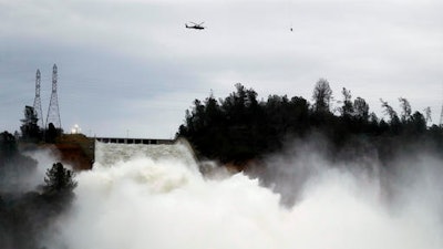 Water gushes down the Oroville Dam's main spillway Wednesday, Feb. 15, 2017, in Oroville, Calif. The Oroville Reservoir is continuing to drain Wednesday as state water officials scrambled to reduce the lake's level ahead of impending storms.